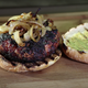 Brat Burger on bun with onions and mustard